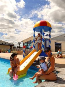 a group of people sitting on a slide in a pool at Kustpark Nieuwpoort in Nieuwpoort