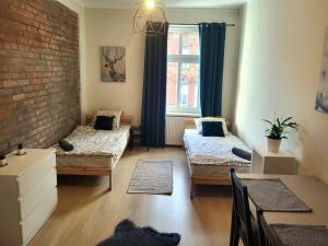 a room with two beds and a brick wall at Lemuria Hostel Wrocławska centrum in Legnica
