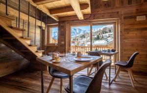 una sala da pranzo con tavolo, sedie e una grande finestra di Fleur des neiges & Spa - Adults only ad Ayas
