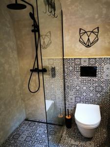 La salle de bains est pourvue d'une douche et de toilettes. dans l'établissement Lesní Apartmány, 