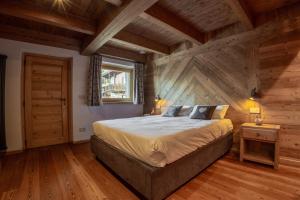 una camera da letto con un grande letto in una camera in legno di Fleur des neiges & Spa - Adults only ad Ayas