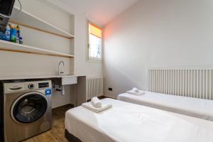 ein Badezimmer mit 2 Betten und einer Waschmaschine in der Unterkunft Árbol del Té in Girona