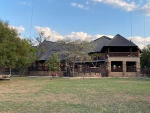 a large brick building with a person standing in front of it at Lodge on Watering Hole , Zebula in Mabula