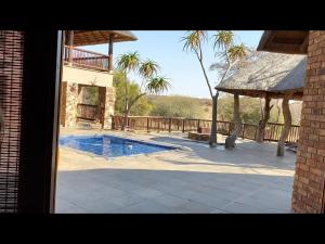 a house with a swimming pool in a yard at Lodge on Watering Hole , Zebula in Mabula