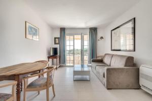 a living room with a couch and a table at PETIT CORAIL Duplex agreable St Raphael - proche mer in Saint-Raphaël
