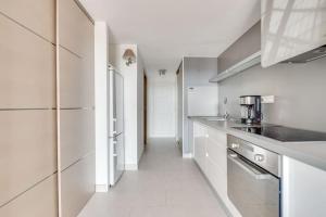 a kitchen with white appliances and a long hallway at PETIT CORAIL Duplex agreable St Raphael - proche mer in Saint-Raphaël