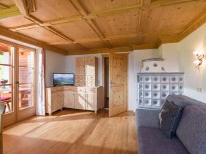 una sala de estar con sofá y techos de madera. en Flecklhütte, en Hopfgarten im Brixental