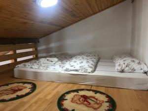 a bed in a room with two pizzas on the floor at Vila Bojana in Gornji Milanovac