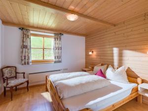 1 dormitorio con cama y techo de madera en Flecklhütte, en Hopfgarten im Brixental