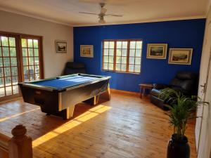 una mesa de billar en una sala de estar con paredes azules en La Maison on Vaal Bed and Breakfast, en Denysville