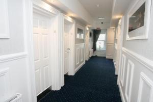 a hallway with white doors and a blue carpet at The Sliding Rock Inn in Galway