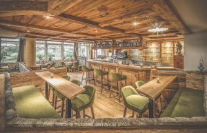 ein Restaurant mit Holzdecken, Tischen und Stühlen in der Unterkunft Hotel Alte Mühle 4 Stelle in Sand in Taufers