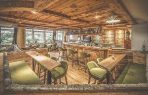 a restaurant with wooden ceilings and tables and chairs at Hotel Alte Mühle 4 Stelle in Campo Tures