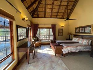 a bedroom with two beds and a desk and a piano at Lodge on Watering Hole , Zebula in Mabula +74 photos