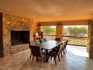 a dining room with a table and a stone fireplace at Lodge on Watering Hole , Zebula in Mabula