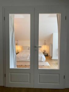 1 dormitorio con 2 puertas de cristal y 1 cama en Sorpe Lodge - Entspannte Urlaubstage am See! en Langscheid