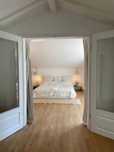 1 dormitorio blanco con 1 cama y TV en Sorpe Lodge - Entspannte Urlaubstage am See! en Langscheid