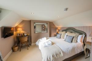 - une chambre avec un grand lit et un bureau dans l'établissement Eliot Arms, à Cirencester