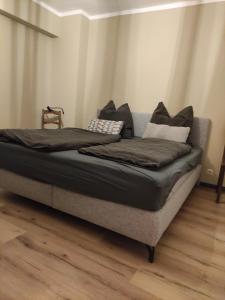 a large bed in a room with a wooden floor at Landperle klein und fein in Altenhof