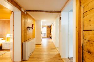 a hallway with wood paneling and a room with a bed at Casa Nacla Sedrun/Surrein in Sedrun