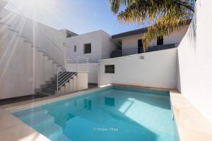 a swimming pool in front of a house at House&Villas - Villa Falaride in Avola