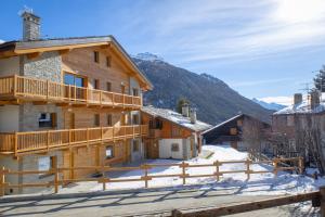 una casa di tronchi con balcone nella neve di Fleur des neiges & Spa - Adults only ad Ayas