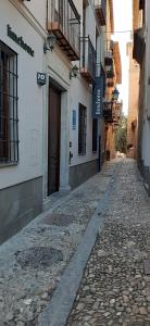 una calle vacía en una ciudad con un edificio en limehome Granada Calle Santa Ana, en Granada