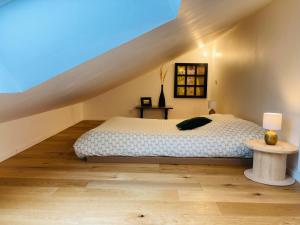 a bedroom with a bed and a staircase at Charmante petite maison rénovée in Quistinic