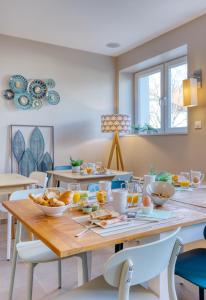 a dining room with a table with food on it at Hôtel L'Orée des plages in Clohars-Carnoët