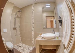 een badkamer met een wastafel en een douche bij Hôtel L'Orée des plages in Clohars-Carnoët