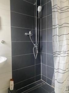 ein Bad mit Dusche und Duschvorhang in der Unterkunft Hohennneuffen Blick in Beuren