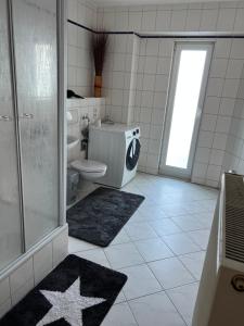 łazienka z toaletą i prysznicem z gwiazdką na podłodze w obiekcie Ferienhaus Zur Sonne w mieście Gotha