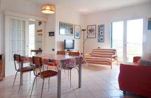 a living room with a table and chairs and a television at Giardino La Panoramica in Rio Marina