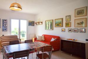 a living room with a red couch and a table at Giardino La Panoramica in Rio Marina