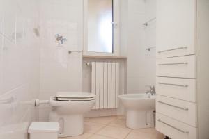 a white bathroom with a toilet and a sink at Giardino La Panoramica in Rio Marina +14 photos