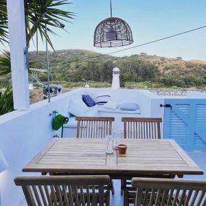 a wooden table and chairs on a patio at New! Casa do Mar - Pedralva - Sagres- Surf & Nature in Vila do Bispo