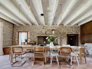 a dining room with a table and chairs and a stone wall at L'ancien Relais de Poste*** in Saint-Dier-dʼAuvergne