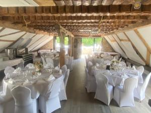 ein Zimmer mit weißen Tischen und Stühlen in einem Zimmer in der Unterkunft Hohennneuffen Blick in Beuren