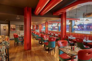a restaurant with red columns and tables and chairs at Malmaison Manchester in Manchester