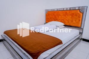 1 cama con cabecero de madera en una habitación en Villa Ikhbar Ciletuh RedPartner, en Cilowa