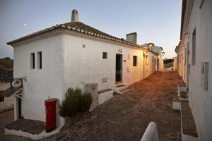 an alley with white buildings and a red trash can at New! Casa do Mar - Pedralva - Sagres- Surf & Nature in Vila do Bispo