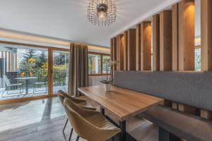 a dining room with a wooden table and chairs at Maraias - Luxury Suites & Apartments in Burgusio