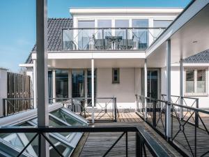einen Balkon mit Glasgeländer und ein Haus in der Unterkunft Juuls Domburg in Domburg