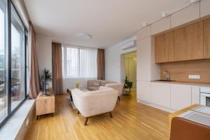 een woonkamer met een bank en een keuken bij 1-bedroom penthouse with underground parking in Rīga