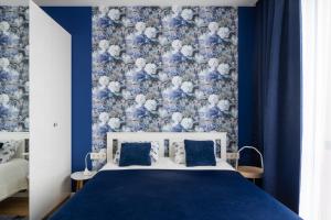 a blue bedroom with a bed with a blue and white wall at 1-bedroom penthouse with underground parking in Rīga