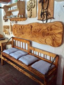 a wooden bench with cushions on a wall at Sedliacka drevenica in Liptovská Osada