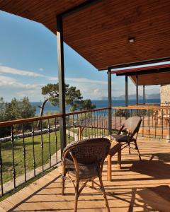 a patio with two chairs and a table on a deck at Rocas Roja Beach Hotel Faralya in Faralya