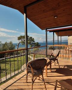 un patio con 2 sillas y una mesa en una terraza en Rocas Roja Beach Hotel Faralya, en Faralya