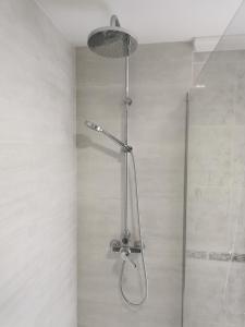 een douche met een douchekop in de badkamer bij El refugio de Torrijos in Málaga