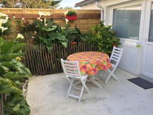 un patio con mesa y 2 sillas en Petite maison dans le jardin en Ars-en-Ré